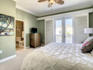 a bedroom with a bed with a ceiling fan and a window at Clearwater Penthouse 5 min Beach walk Heated Pool in Clearwater Beach