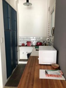 DEPARTAMENTO EN BALVANERA في بوينس آيرس: مطبخ مع مغسلة بيضاء وارضية خشبية