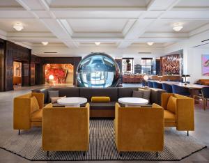 a lobby with a large couch and tables and chairs at 21c Museum Hotel St Louis in Saint Louis