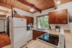 a kitchen with a white refrigerator and wooden cabinets at 24SL - BBQ - Pets Ok - A Couple's Getaway! home in Glacier