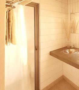 uma casa de banho com um lavatório e um chuveiro em Hotel Tulor em San Pedro de Atacama