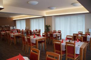 a restaurant with tables and chairs with red napkins on them at Hotel Krystal in Hodonín