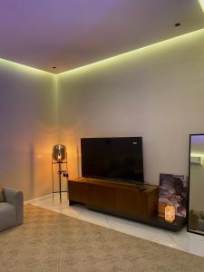 STAY Villa في الرياض: غرفة معيشة مع تلفزيون بشاشة مسطحة على جدار