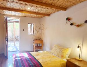 1 dormitorio con cama y techo de madera en Hotel Tulor, en San Pedro de Atacama