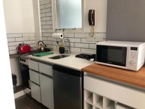 una pequeña cocina con microondas y fregadero en DEPARTAMENTO EN BALVANERA en Buenos Aires