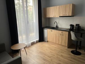 a kitchen with a sink and a table and a counter at Aquarius Kilińskiego szafir in Grodzisk Mazowiecki