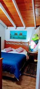 - une chambre avec un lit bleu dans l'établissement Hostal OlaBrava, à Pichilemu