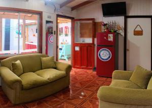 - un salon avec un canapé et un réfrigérateur dans l'établissement Hostal OlaBrava, à Pichilemu