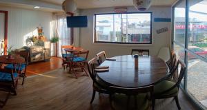 comedor con mesa de madera y sillas en Hostal OlaBrava, en Pichilemu