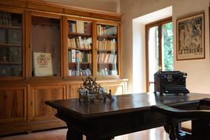 um quarto com uma mesa de madeira e uma estante de livros em Residenza Villa Degli Ochi em Sagginale