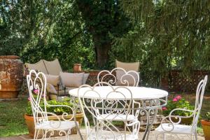 a white table and chairs in a yard with a couch at Residenza Villa Degli Ochi in Sagginale