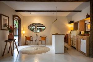 a kitchen with a counter and a table and a mirror at Na Praça Hotel in Trancoso