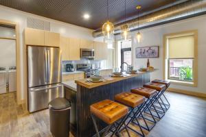 a large kitchen with a bar with stools in it at Downtown Millersburg Retreat with Sleek Interior! in Millersburg