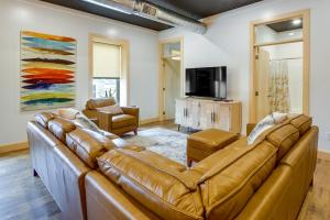 a living room with a leather couch and a television at Downtown Millersburg Retreat with Sleek Interior! in Millersburg