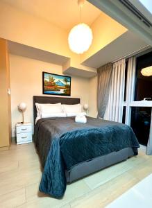 1 dormitorio con cama grande y ventana grande en New & Modern Cozy 1BR w/ Balcony@BGC, WiFi 300MBPS, en Manila