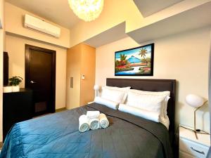 1 dormitorio con 1 cama grande y 2 almohadas gratuitas en New & Modern Cozy 1BR w/ Balcony@BGC, WiFi 300MBPS, en Manila