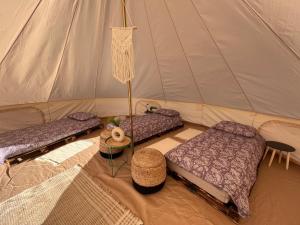 a room with two beds in a tent at Glamping Rusne in Rusnė