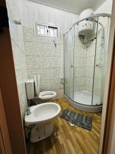 a small bathroom with a toilet and a shower at La Posada del Viajero in Durazno