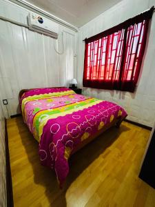 ドゥラスノにあるLa Posada del Viajeroのベッドルーム1室(カラフルな毛布付きのベッド1台付)