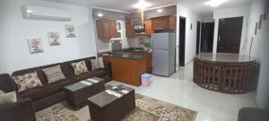 Il comprend un salon avec un canapé et une cuisine. dans l'établissement حجز شاليهات مارينا دلتا ومارينا لاجونز, à Al Ḩammād
