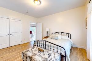 a bedroom with a bed and a wooden floor at Maine Country Getaway in Holden