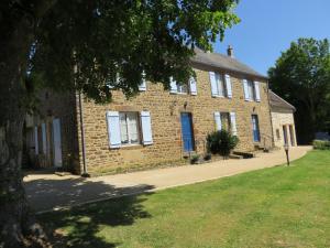 une maison en briques avec un arbre devant elle dans l'établissement Les Quatre Saisons, à Moitron-sur-Sarthe