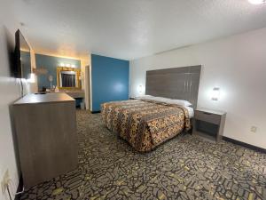 a hotel room with a bed and a bathroom at Countryside Inn in Malakoff