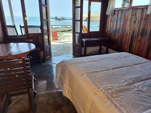 1 dormitorio con cama, mesa y ventanas en Hotel Las Aldas, en Casma