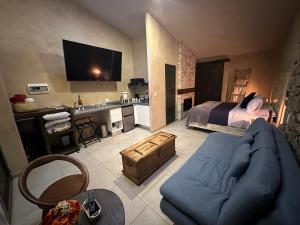 - un salon avec un canapé bleu et un lit dans l'établissement L’Appuntamento en Val'Quirico, à Santeagueda