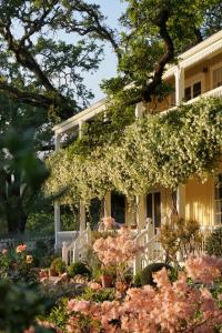 a white house with flowers in front of it at Beltane Ranch in Glen Ellen