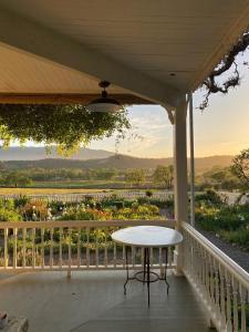 - une table sur la terrasse couverte d'une maison avec vue dans l'établissement Beltane Ranch, à Glen Ellen