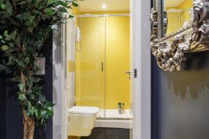 uma casa de banho com um WC e um chuveiro amarelo em Opulence Studio in Sheffield em Sheffield
