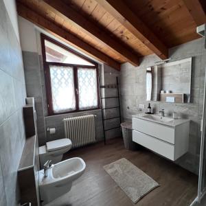 uma casa de banho com um lavatório, um WC e um espelho. em VILLA LIDO - Lake Como em Colico