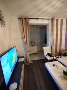uma sala de estar com uma televisão de ecrã plano e um sofá em Alba Crikvenica em Crikvenica
