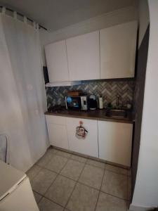 uma pequena cozinha com armários brancos e um micro-ondas em Alba Crikvenica em Crikvenica