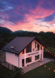 a house with a black roof on top of it at Impressive Târgu Ocna in Târgu Ocna