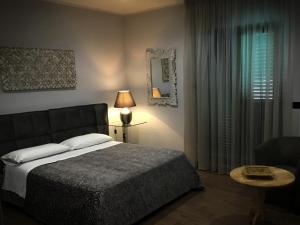 um quarto com uma cama, um candeeiro e uma janela em Erania Apartments em Sala Consilina