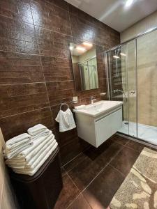 a bathroom with a sink and a glass shower at Timeless Elegance: Vintage 3-Bedroom Apartment 