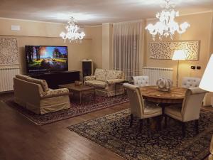 a living room with a table and chairs and a tv at Erania Apartments in Sala Consilina