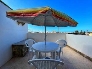 a table and chairs with an umbrella on a balcony at Timeless Elegance: Vintage 3-Bedroom Apartment 