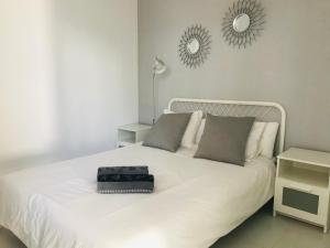 a white bed with a black bag sitting on it at Olas de Lobos in Corralejo +52 photos