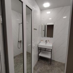 La salle de bains blanche est pourvue d'un lavabo et d'un miroir. dans l'établissement Checkpoint Goght, à Goghtʼ
