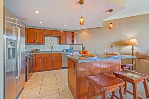 a kitchen with wooden cabinets and a large island at HK #537 in Lahaina