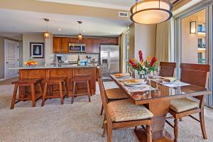 a dining room with a table and chairs and a kitchen at HK #539 in Lahaina