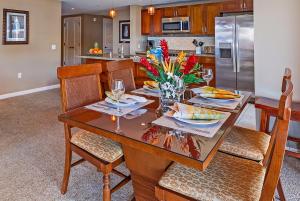 a kitchen with a dining room table with flowers on it at HK #539 in Lahaina