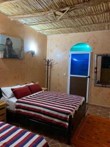 a bedroom with a large bed and a window at Gite D'Etape Amced in Goulmima