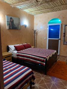 een slaapkamer met 2 bedden en een raam bij Gite D'Etape Amced in Goulmima