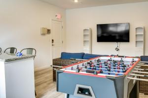 a living room with a foosball table in front of a tv at Rehoboth Beach Vacation Rental with Community Pool! in Rehoboth Beach