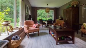 een woonkamer met een tafel en stoelen bij Het Witte Boshuis Vierhouten in Vierhouten