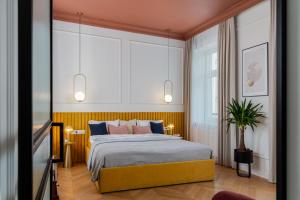 a bedroom with a bed with blue and pink pillows at Premium apartment in Parisian style in the heart of Old Krakow in Krakow